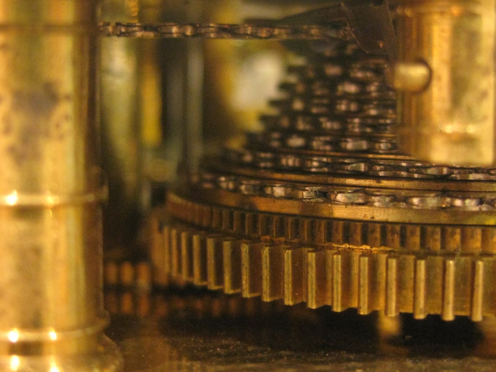 Detalle de los engranajes dentados y la cadena de transmisión en el interior de un reloj antiguo