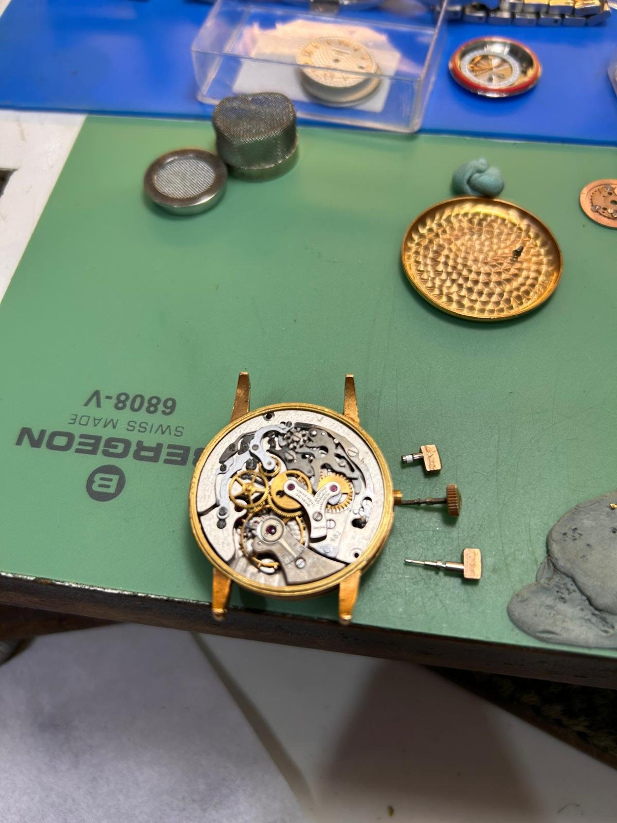 Reloj Universal Genève Tri-Compax desmontado sobre mesa de trabajo relojero