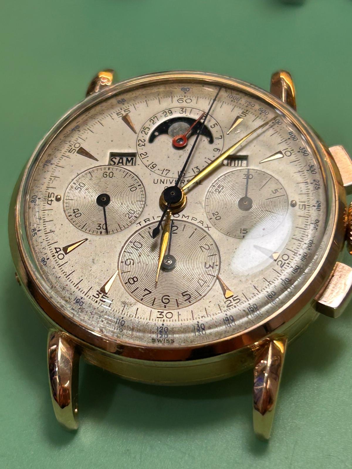 Reloj Universal Genève Tri-Compax con esfera clásica sobre mesa de trabajo