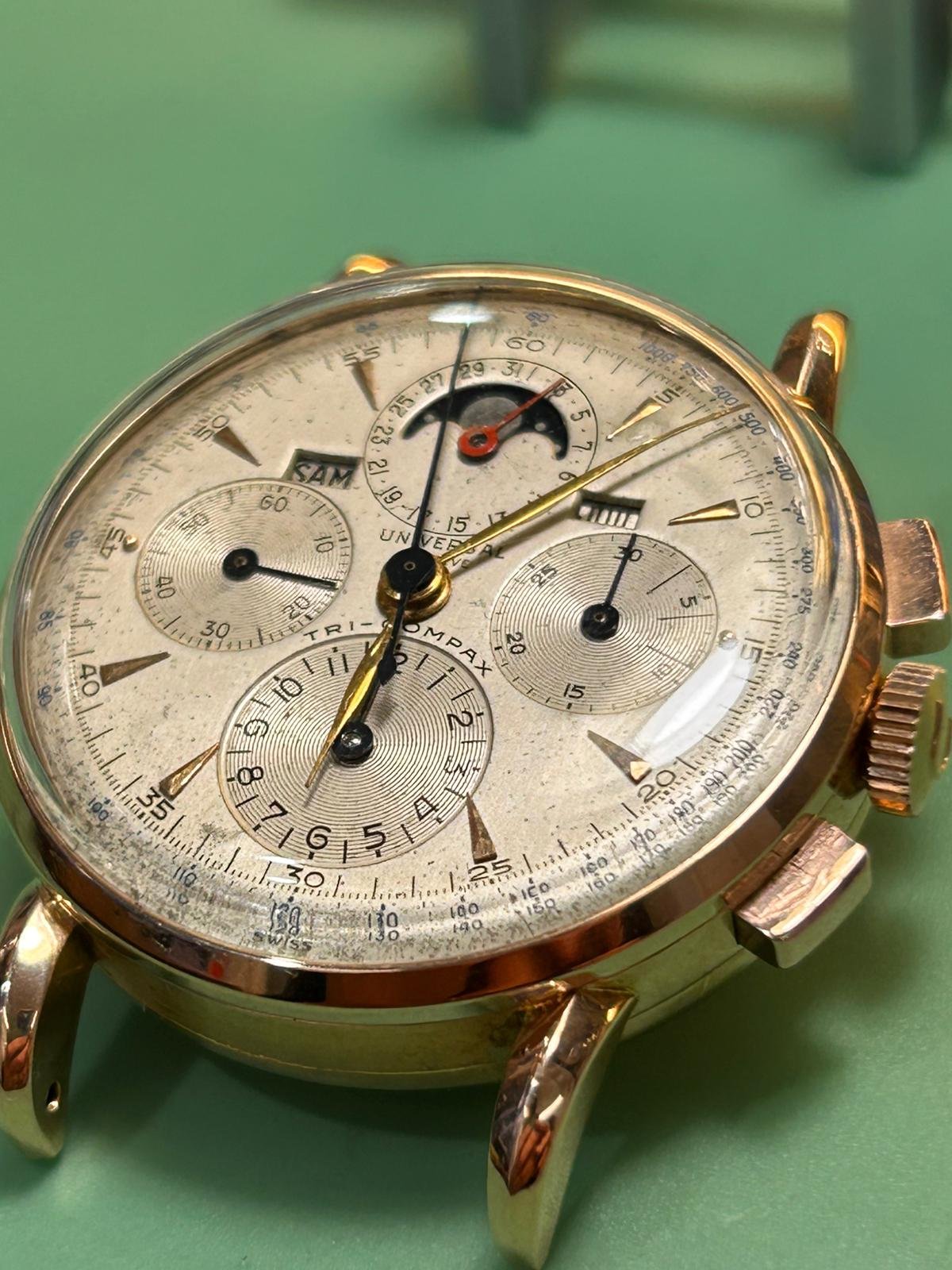 Reloj Universal Genève Tri-Compax con esfera clásica sobre mesa de trabajo